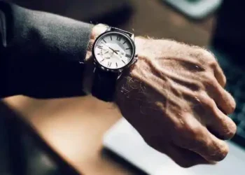 رجل يرتدي ساعة ويشير الى اهمية عامل الزمن