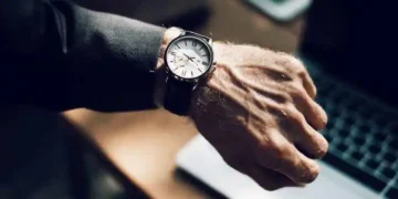 رجل يرتدي ساعة ويشير الى اهمية عامل الزمن