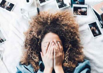 زوجة مغطٍي وجهها بيديها ومحاطة بصور متناثرة