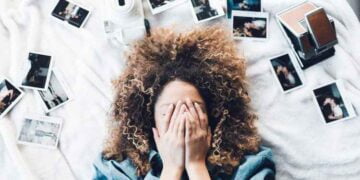 زوجة مغطٍي وجهها بيديها ومحاطة بصور متناثرة