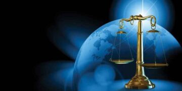 ميزان العدالة ذهبي وخلفه الكرة الارضية بلون ازرق