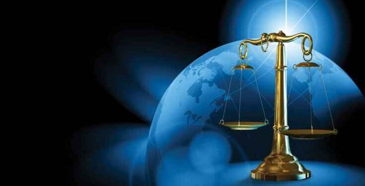 ميزان العدالة ذهبي وخلفه الكرة الارضية بلون ازرق